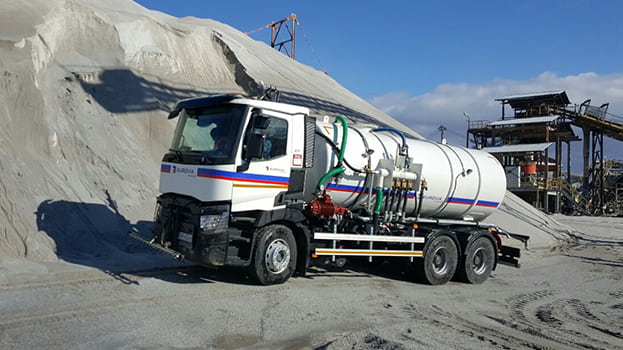 Sprengwagen auf der Baustelle beim Einsatz zur Staubminderung.